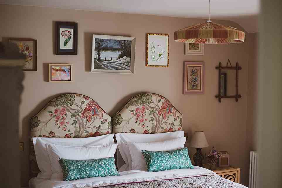 The room where Lucy stays (pictured above) is a 'bucolic den of embroidery, floral headboards and patterned throws'