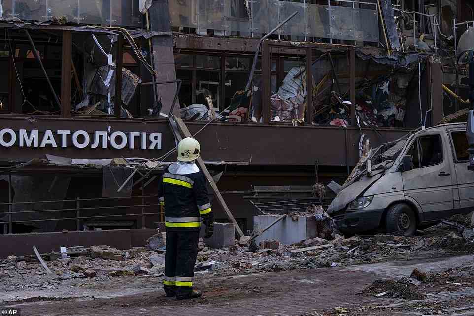Firefighters work at the scene of a residential building following the cruise missile strikes, some of which were fired from Russian long-range Tu-22 bombers deployed from Belarus for the first time