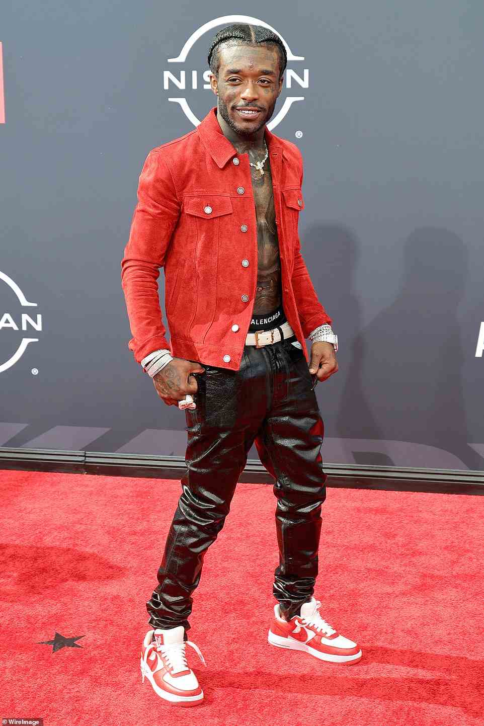 Showing skin: Rapper Lil Uzi Vert, 26, flashed his abs as he opted to go without a shirt and wore an open red suede jacket, black leather pants, and Nike sneakers