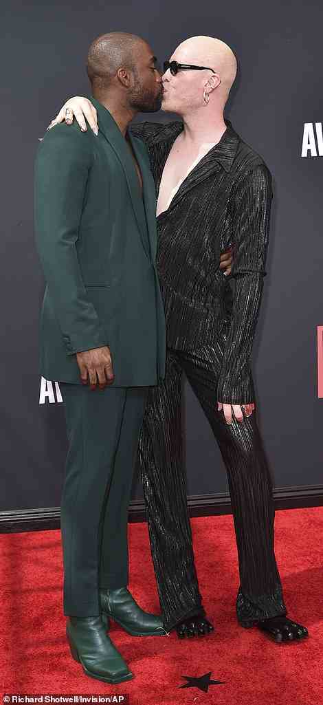 Stylish couple: Madrick rocked a forest green suit and matching boots
