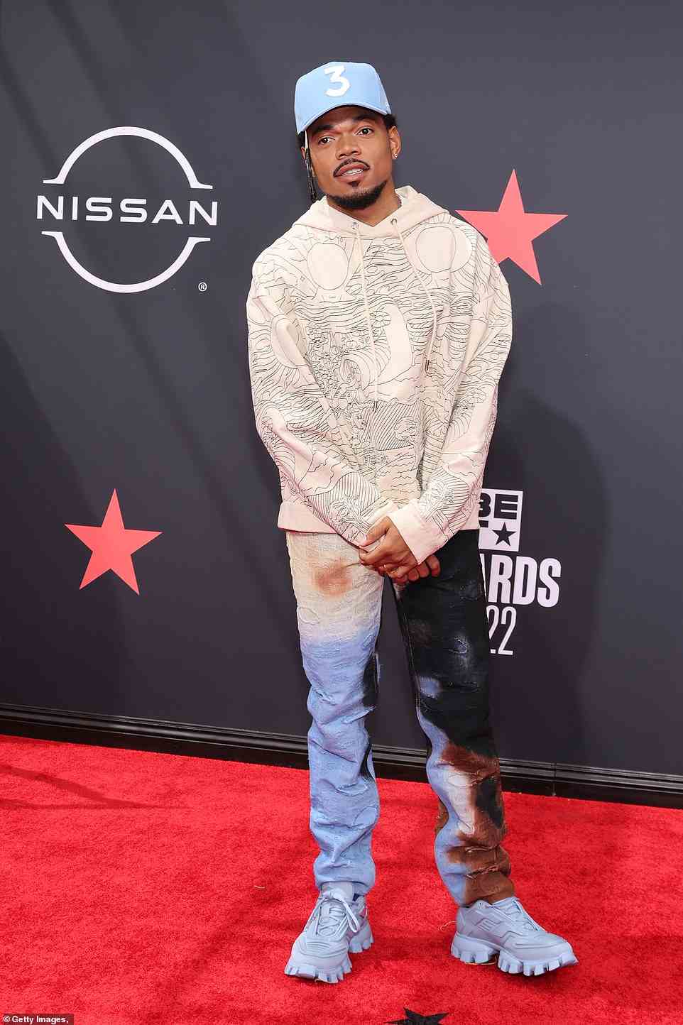 Cool guy: Chance the Rapper, 29, looked cool as ever in a graphic hoodie and multi-color jeans, which he paired with blue sneakers and a baby blue hat