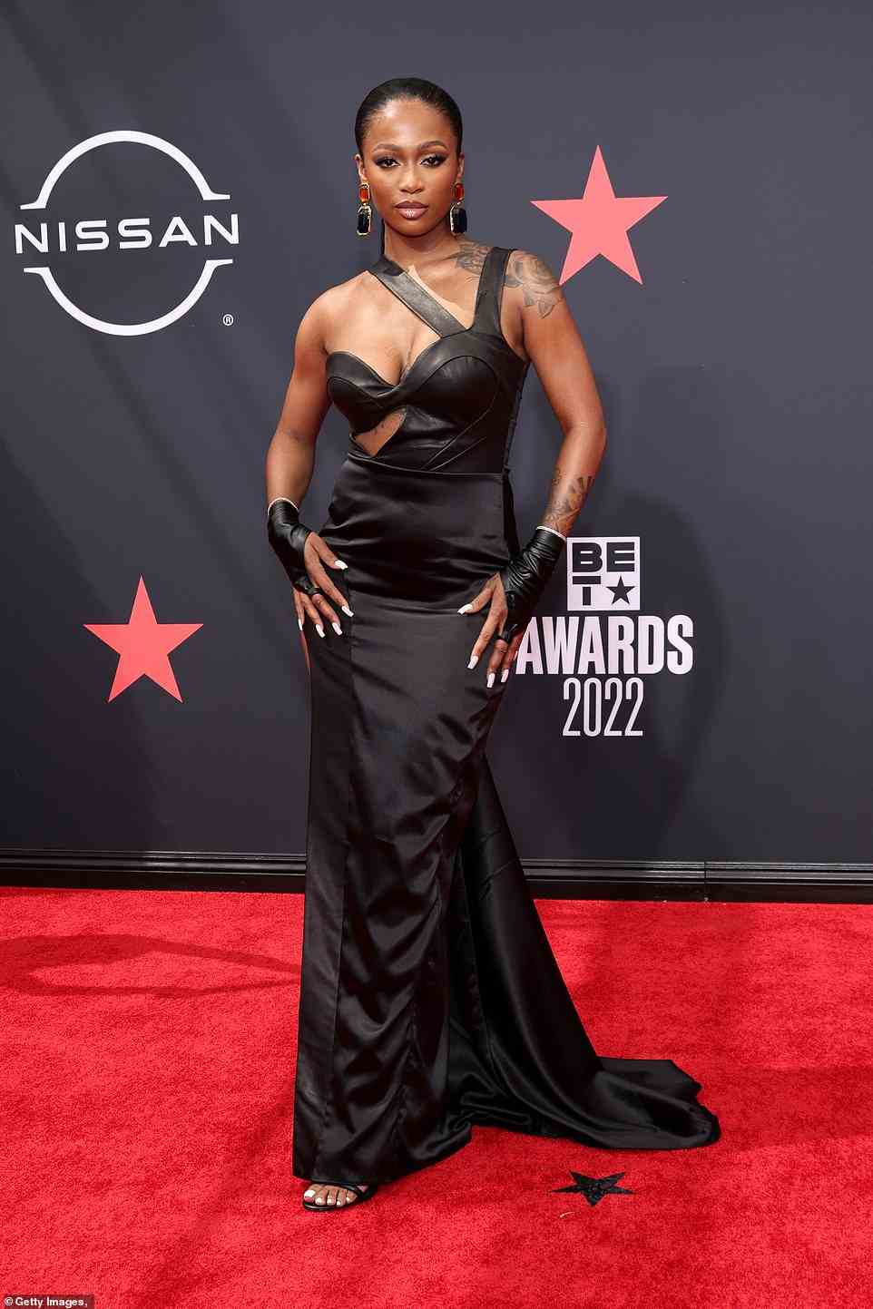 Sizzling: Rapper Dess Dior, 23, slipped her famous curves into a sizzling black gown with a front cut-out, which she paired with black leather gloves