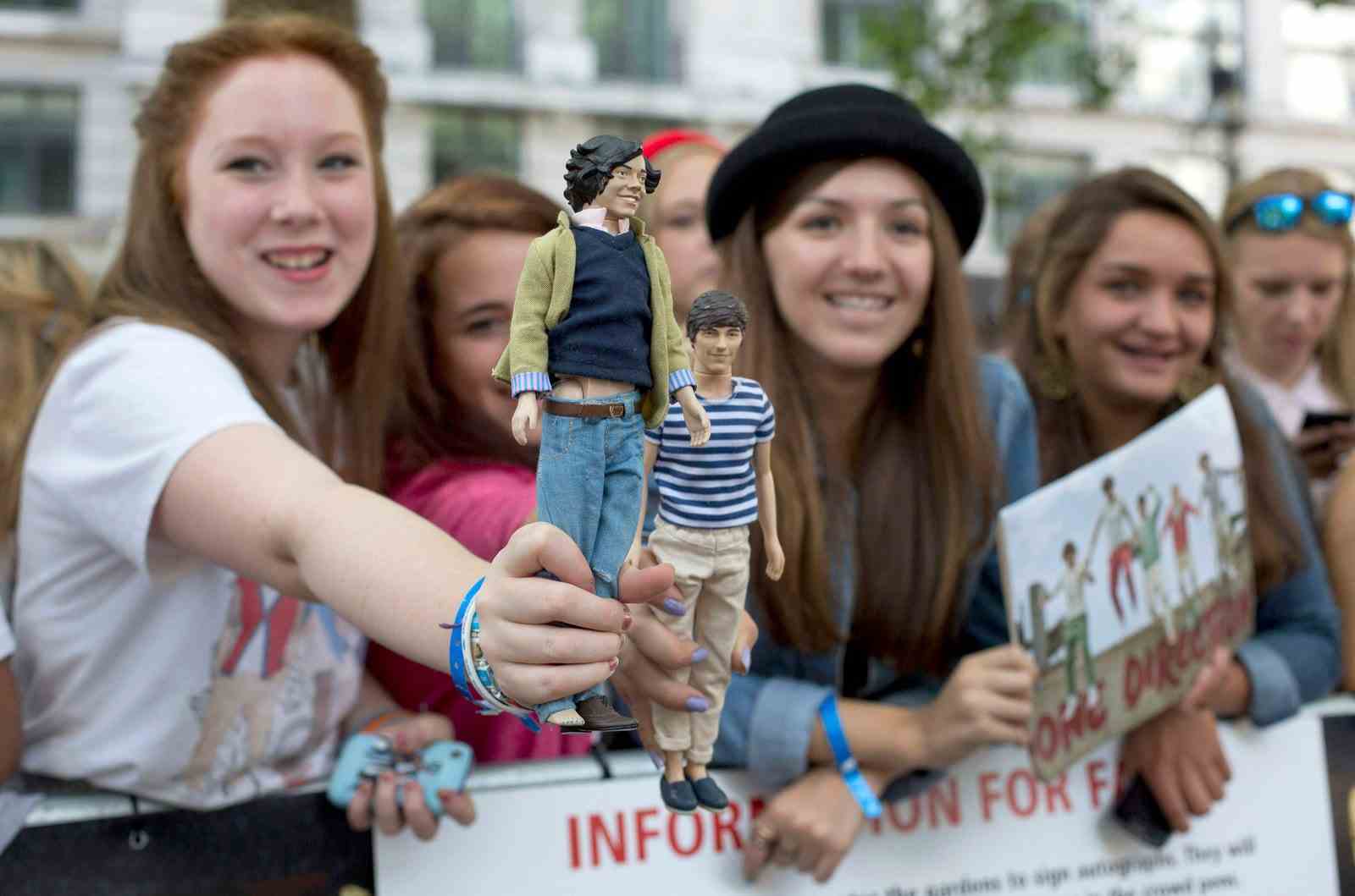 Fans halten Puppen, die die Bandmitglieder Harry Styles und Louis Tomlinson von One Direction darstellen.