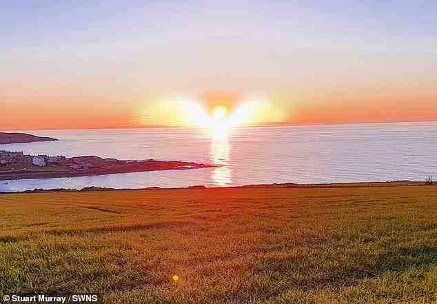 Dies ist der unglaubliche Moment, in dem der Amateurfotograf Stuart Murray, 56, einen Sonnenuntergang fotografierte und das Licht in Form eines Engels in der Nähe seines Hauses in Portsoy, Aberdeenshire, Schottland, einfing