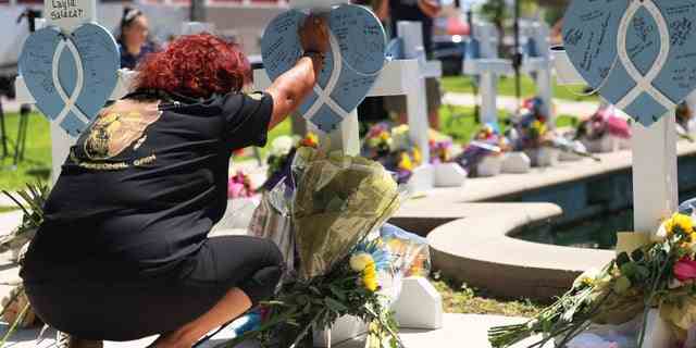Eine Trauernde legt ihre Hand auf ein Denkmal für ein Opfer der Massenerschießung am Dienstag in einer Grundschule auf dem Stadtplatz der Stadt Uvalde am 26. Mai 2022 in Uvalde, Texas. 