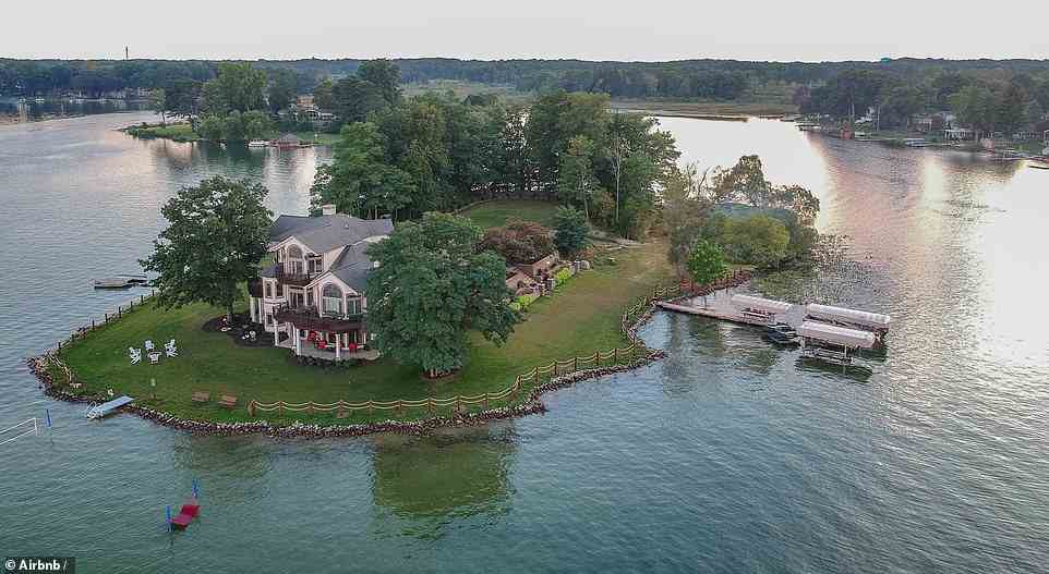 'Take a trip to Paradise Island and feel the fantasy of renting an island right here in Michigan,' says the listing of this four-bedroom abode in the centre of Goguac Lake