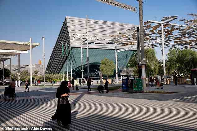 An Emirati woman walks in front of the Saudi Arabian pavilion at Dubai's tech Expo 2020