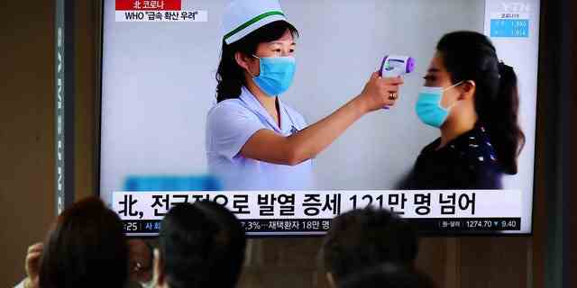 Menschen sehen sich am 17. Mai 2022 an einem Bahnhof in Seoul, Südkorea, einen Fernseher an, der einen Nachrichtenbericht über den COVID-19-Ausbruch in Nordkorea ausstrahlt.