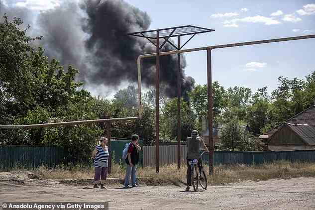 Ein Mann auf einem Fahrrad sieht gestern zu, wie Rauch von einer Explosion in Siwersk, Ukraine, aufsteigt
