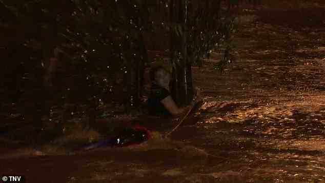 The terrified woman clung to a tree as she was battered by flood waters in southwestern Sydney