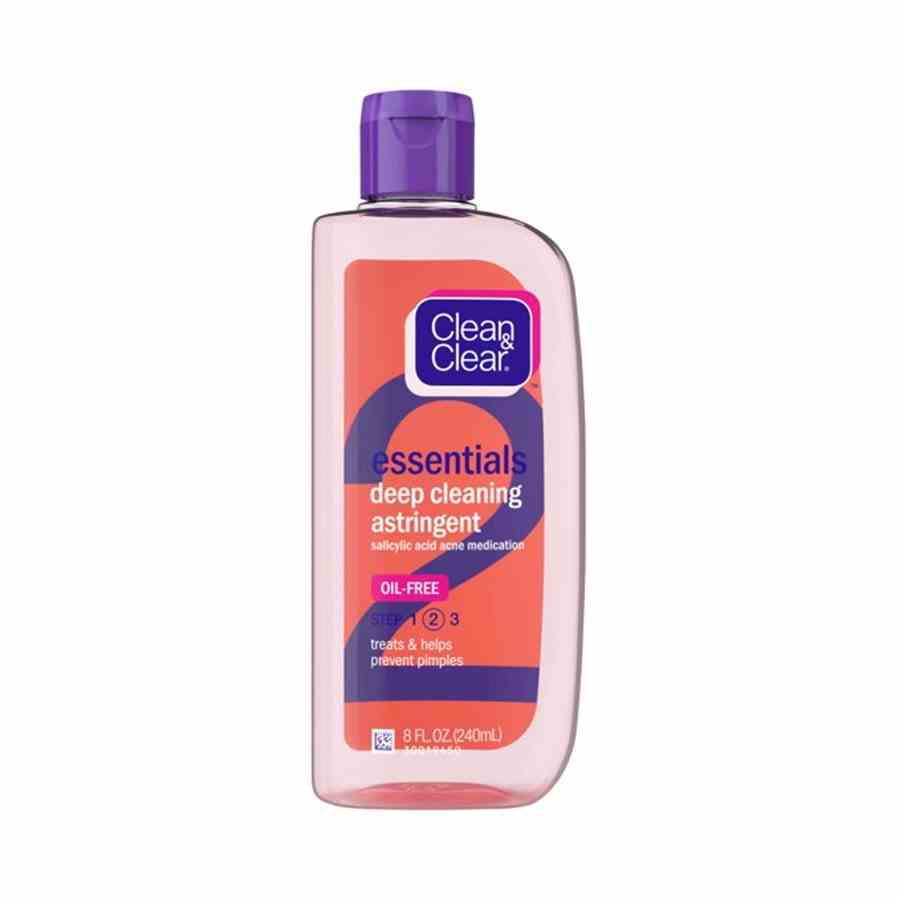 Clean & Clear Essentials Ölfreie Tiefenreinigung Adstringierende Flasche mit durchscheinendem rosa Reinigungsmittel mit orangefarbenem und violettem Etikett und violettem Deckel auf weißem Hintergrund