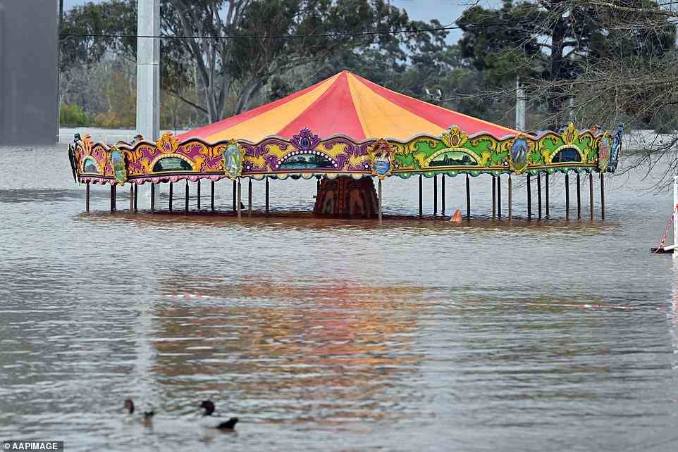 Residents of the Wallacia Caravan Park, areas of Emu Plains and parts of Penrith, were told to evacuate overnight (pictured, flooded amusement ride at Camden on Sunday)