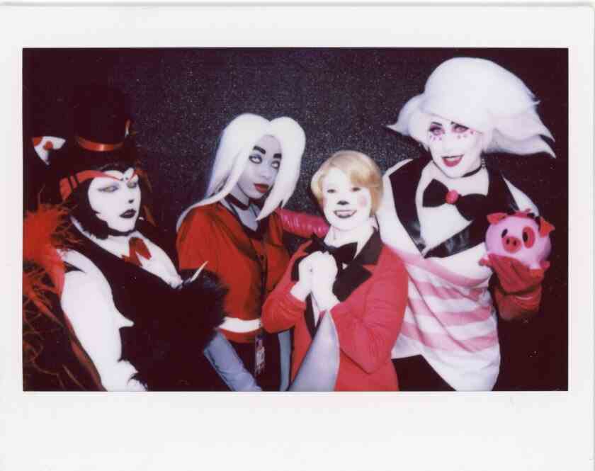 Vier Leute, die mit weißen Gesichtern und roten und schwarzen Kostümen cosplayen.