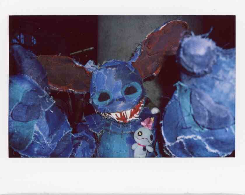 Ein blaues Cosplay-Monster mit großen Fledermausohren und großen spitzen Zähnen.