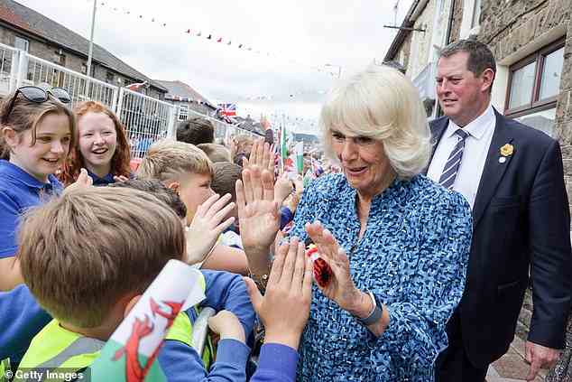 Elsewhere, the royal couple met with the crowds of people, shaking hands with royal fans - and Camilla even joined in with a high five when greeting a school pupil