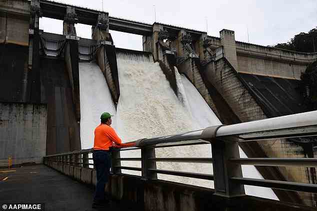 Sydney Water bittet alle in diesen Gebieten, derzeit auf unnötigen Wasserverbrauch zu verzichten (im Bild ein Arbeiter, der den Abfluss der Überlaufrinne des Warragamba-Staudamms überwacht)