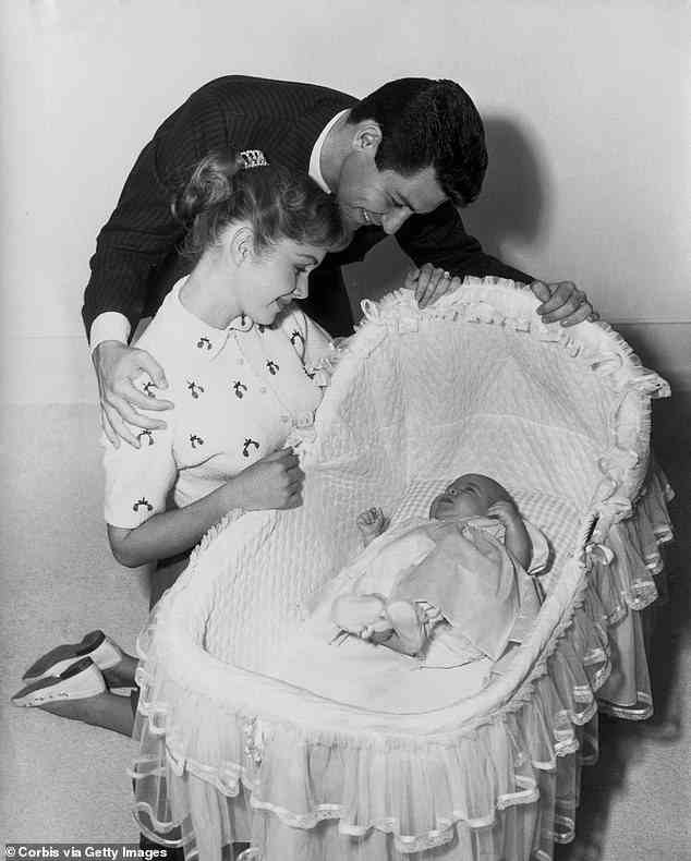 However, Reynolds (pictured with her first husband, Eddie Fisher, after the birth of her daughter, Carrie) revealed that seven months into the pregnancy, the baby 'died inside of her'
