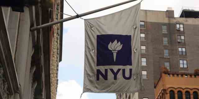Eine Flagge der New York University (NYU) weht am 25. August 2020 in New York City vor einem Covid-19-Testzelt vor der NYU Business School.