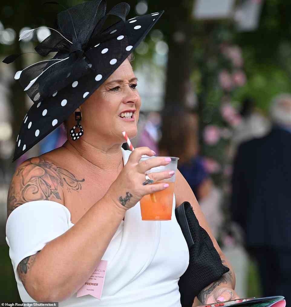 Getting into the spirit of the day! One reveller sipped on a glass of Aperol as they arrived the races ahead of the big day beginning