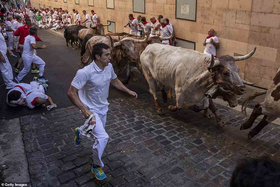 Die Feierlichkeiten begannen gestern, als Nachtschwärmer sich gegenseitig auf einem überfüllten Platz in Pamplona mit Wein übergossen, und setzten sich heute Morgen mit dem Bull Run fort