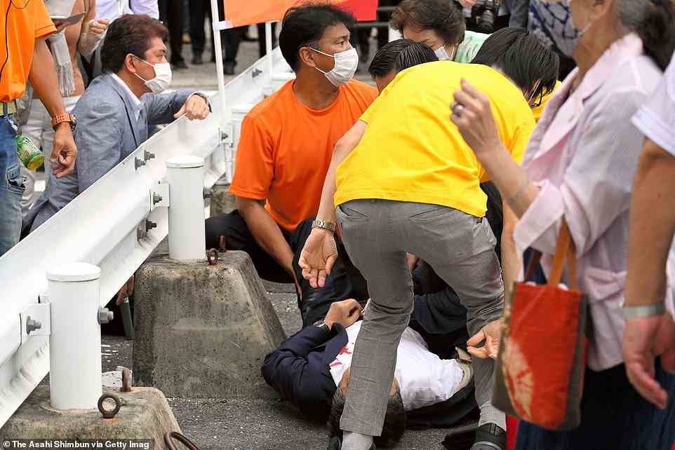 Former Prime Minister Shinzo Abe bleeds from chest on the ground after being shot in front of Yamatosaidaiji Station