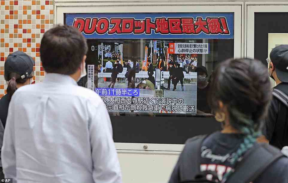 People watch TV news reporting Japan's former Prime Minister Shinzo Abe was shot, in Tokyo