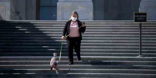 VEREINIGTE STAATEN – 3. März: Die Abgeordnete Susan Wild, D-Pa., geht mit ihrem Hund Zoey spazieren, als sie nach einer Abstimmung in Washington am Mittwoch, dem 3. März 2021, die Stufen des Hauses hinuntergeht. 