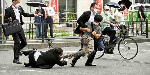 Ein Mann, von dem angenommen wird, dass er den ehemaligen japanischen Premierminister Shinzo Abe erschossen hat, wird auf diesem Foto von The Asahi Shimbun am 8. Juli 2022 von Polizisten in Nara, Westjapan, angegriffen. 