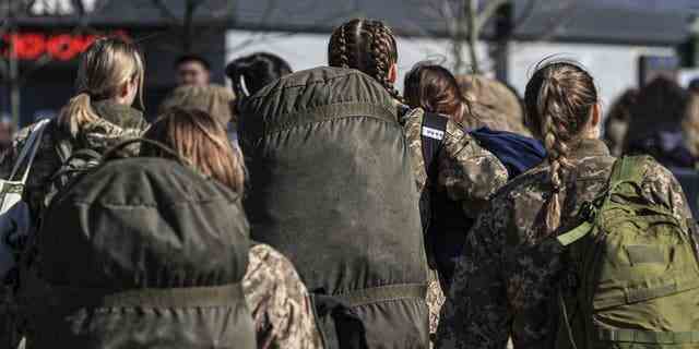Ukrainische Soldatinnen werden gesehen, bevor sie sich an die Front begeben, während ukrainische vertriebene Zivilisten am 24. 