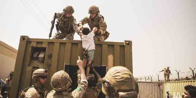 Auf diesem vom Verteidigungsministerium bereitgestellten Foto werden amerikanische Truppen gezeigt, die Menschen helfen, sich in Sicherheit zu bringen.