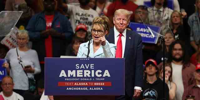 Die republikanische Kandidatin des US-Repräsentantenhauses, die frühere Gouverneurin von Alaska, Sarah Palin (L), spricht, während der ehemalige US-Präsident Donald Trump (R) während eines zusieht "Rette Amerika" Kundgebung im Alaska Airlines Center am 09. Juli 2022 in Anchorage, Alaska. 