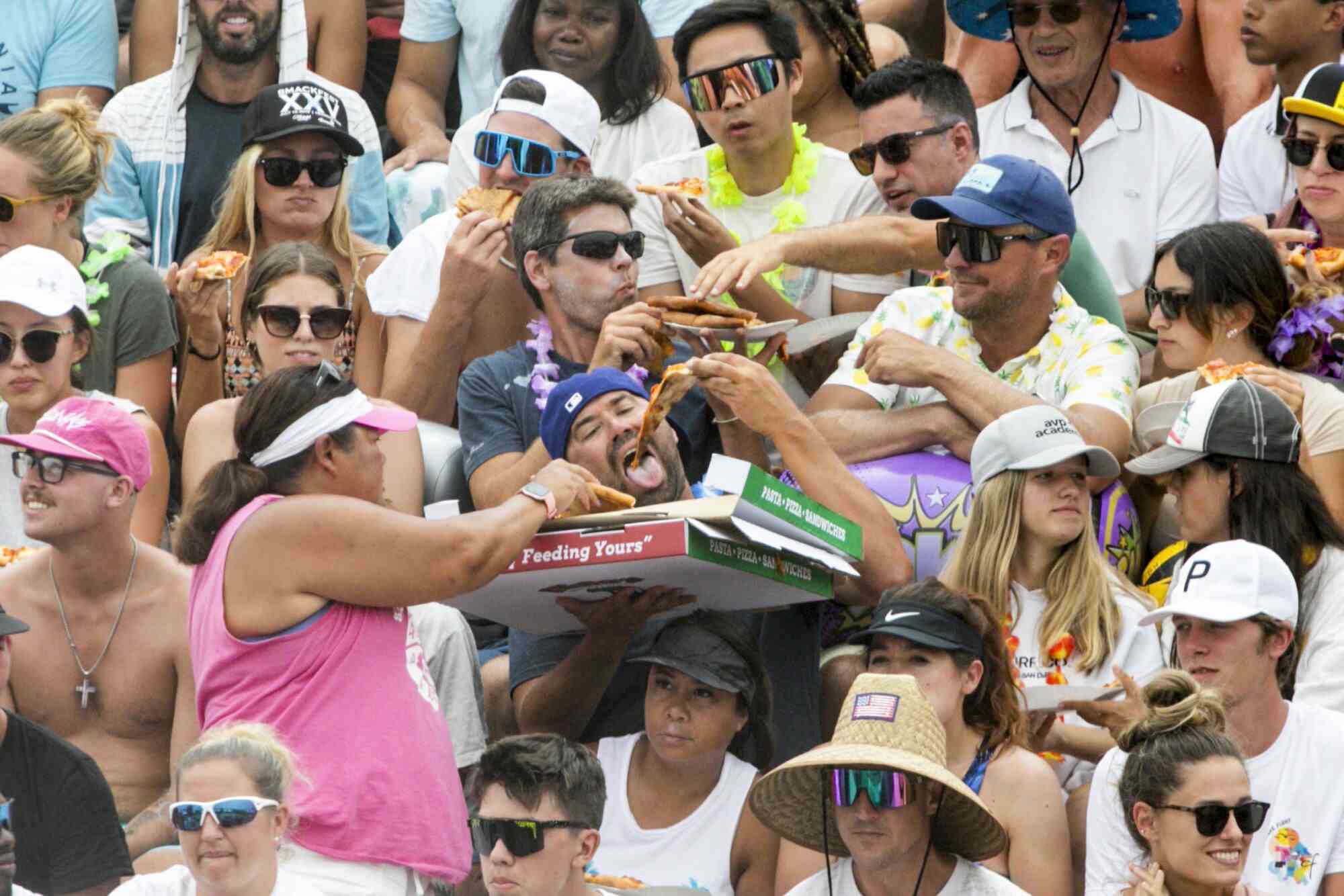 Fans genießen Pizza, während sie sich das Finale bei den AVP Hermosa Beach Open ansehen.