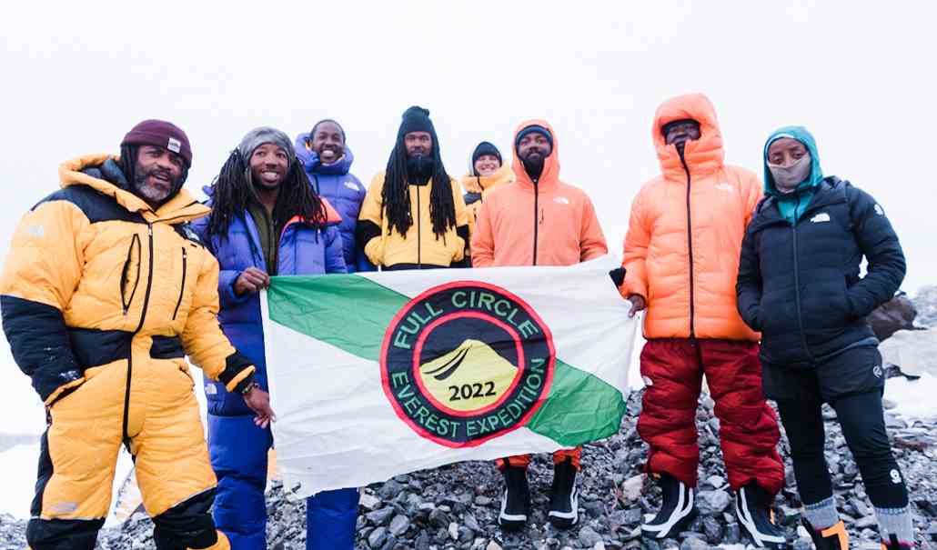 ein Foto von acht strahlenden Full Circle Bergsteigern, die lächeln und ein Banner der Full Circle Everest Expedition 2022 halten