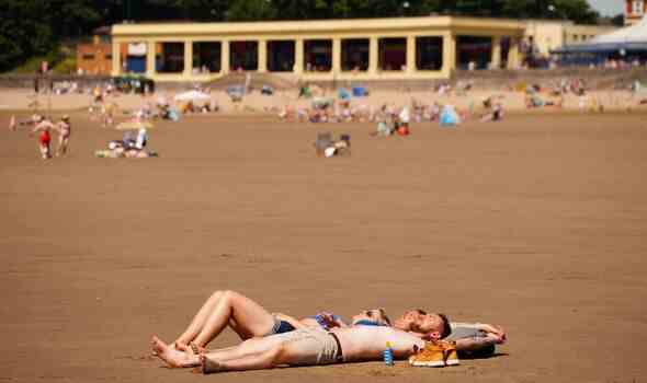 Menschen am Strand von Barry Island, Wales genießen das heiße Wetter