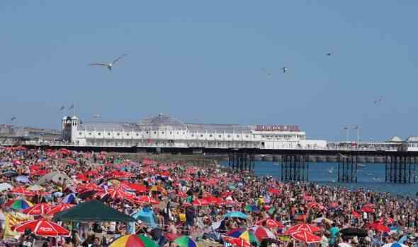 Die Menschen genießen das warme Wetter am Strand von Brighton in West Sussex