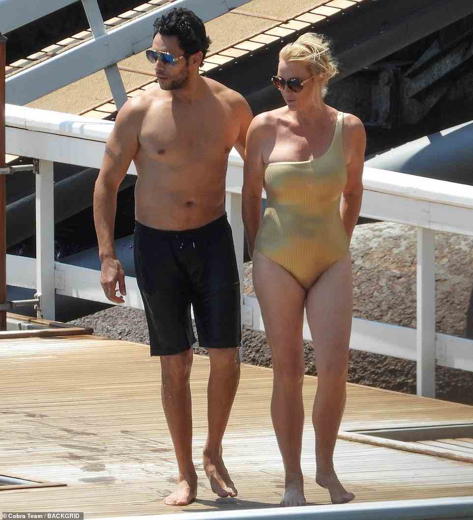 Lee showed off her figure in a striking gold one-piece, while Youcef wore black board shorts