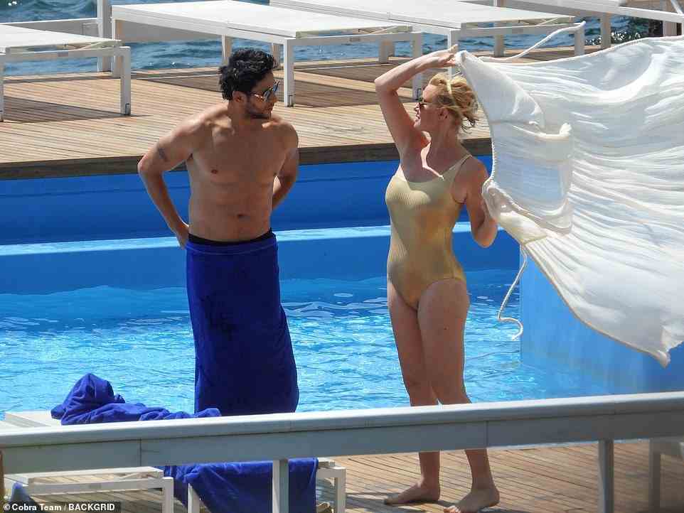 Lee through on a gauzy white cover-up over her gold swimsuit, while Youcef wrapped a towel around his waist