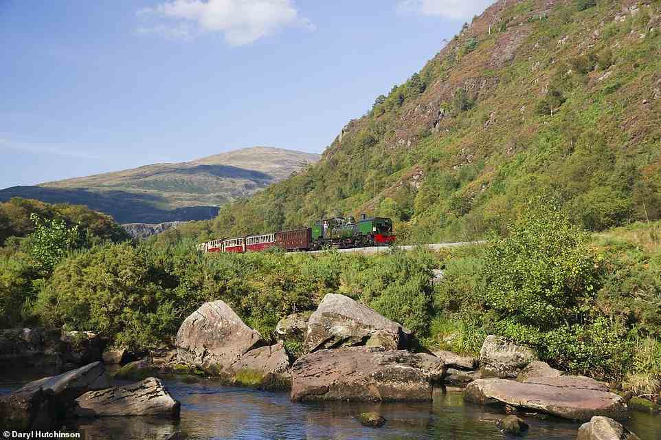 In Wales, the Ffestiniog Railway and its sister line, the Welsh Highland, run through Snowdonia National Park. Above, a Welsh Highland train heads south from the village of Beddgelert into the Aberglaslyn Pass