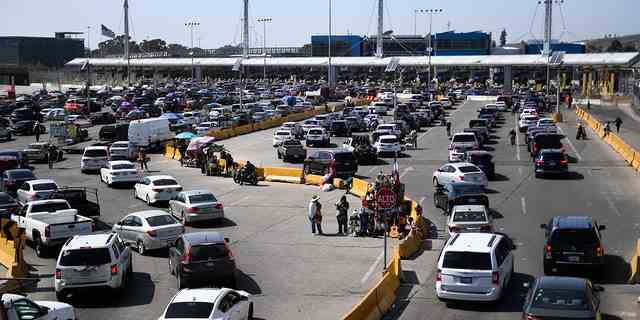 Fahrzeuge warten am 9. April 2022 auf die Einfahrt in den Zoll- und Grenzschutz der Vereinigten Staaten (CBP) San Ysidro Port of Entry entlang der US-mexikanischen Grenze in Tijuana, Bundesstaat Baja California, Mexiko. 