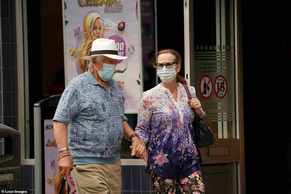 BIRMINGHAM: A man and a woman wearing medical face masks on Thursday in Kings Heath, Birmingham. Many people are choosing to continue wearing face coverings to reduce their risk of spreading or catching Covid