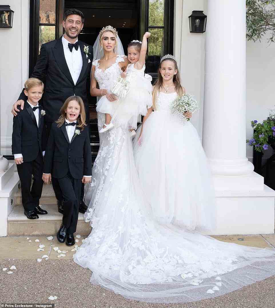 Happy family: The couple posed for a set of family snaps outside the venue along with their four children Lavinia, nine, twins Andrew and James, seven, and their youngest daughter, two