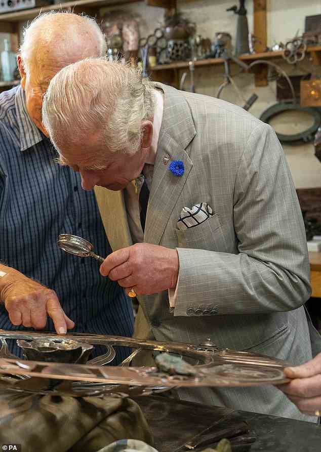 Der Prinz von Wales begutachtete bei seinem Besuch in Newlyn Harbor die Details in einigen Kupferwerken