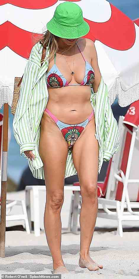 Glückliche Heidi in der Sonne: Das 49-jährige Supermodel und Fernsehmoderatorin spazierte mit Sonnenbrille an einem weißen Sandstrand in Miami Beach, Florida, als sie die Zuschauer anlächelte