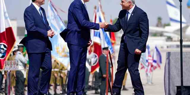 Präsident Joe Biden wird vom israelischen Premierminister Yair Lapid (rechts) und Präsident Isaac Herzog (links) begrüßt, als sie an einer Ankunftszeremonie teilnehmen, nachdem Biden am Mittwoch, dem 13. Juli 2022, am Flughafen Ben Gurion in Tel Aviv angekommen ist.