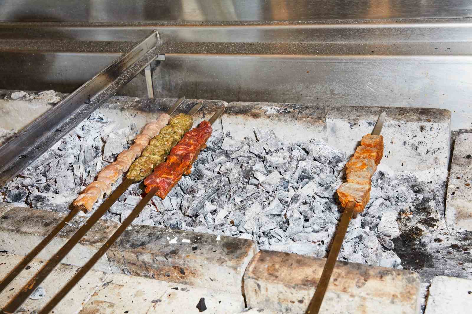 Kebabs, die über Holzkohle ruhen.