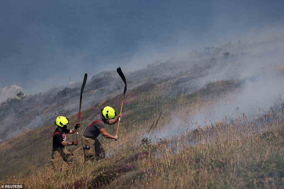 Firefighters attend a gorse bush fire during the heatwave near Zennor in Cornwall this afternoon