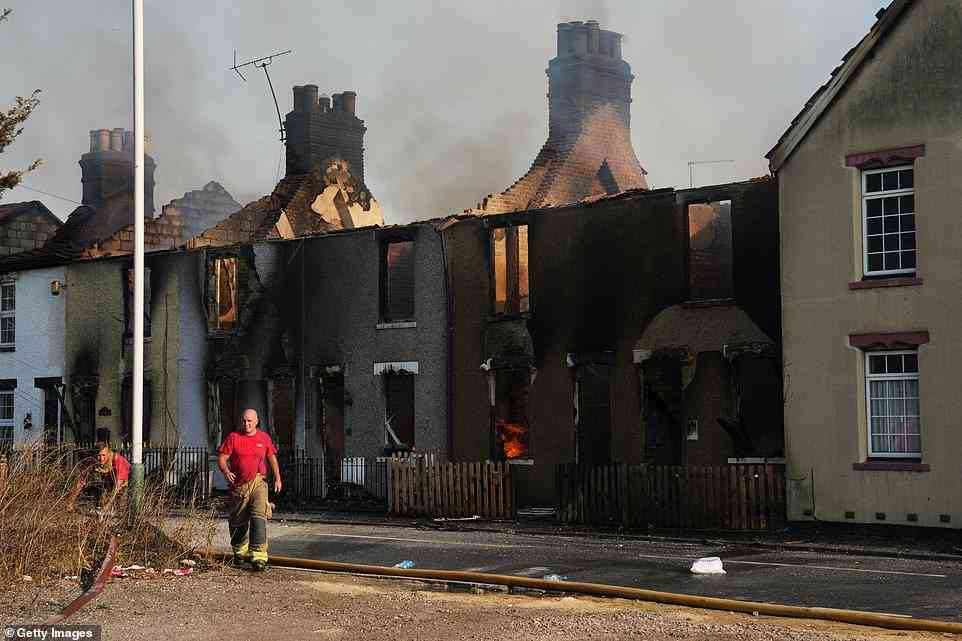 Emergency services fight fires in a row of houses on July 19, 2022 in Wennington as at least five homes have been gutted