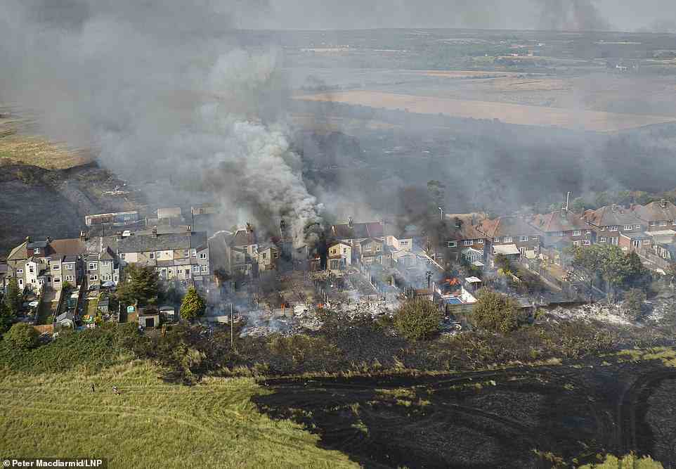 Homes in Wennington can be seen on fire and completely blackened by the raging wildfire amid devastating temperatures