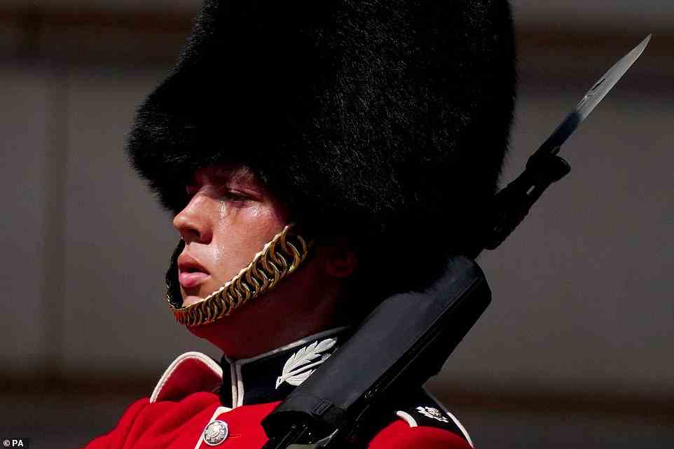 A member of F Company Scots Guards swelters during the Changing of the Guard ceremony at Buckingham Palace today