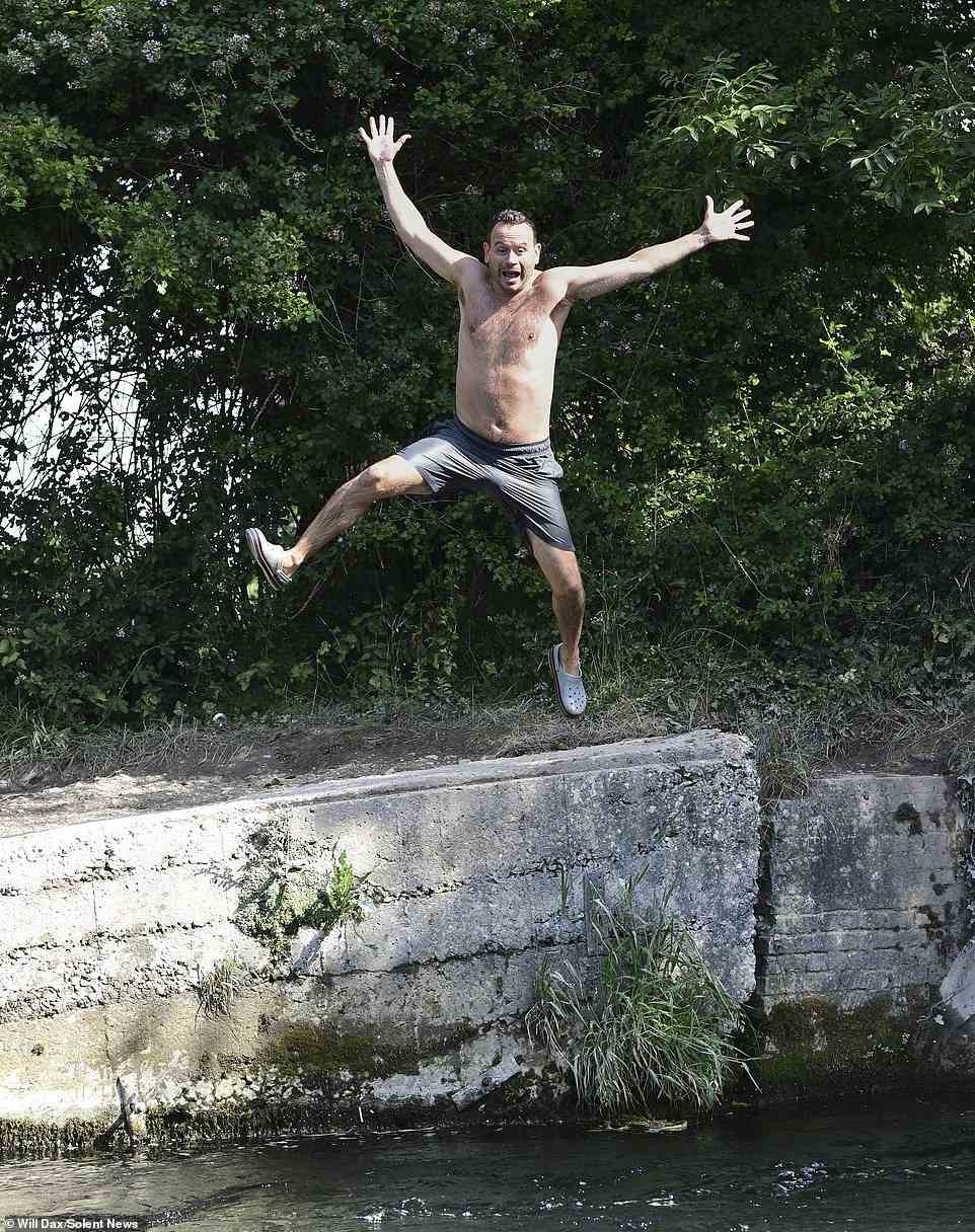 Peter Dolby jumps into the water at Compton Lock in Winchester today on what is expected to be the hottest day on record